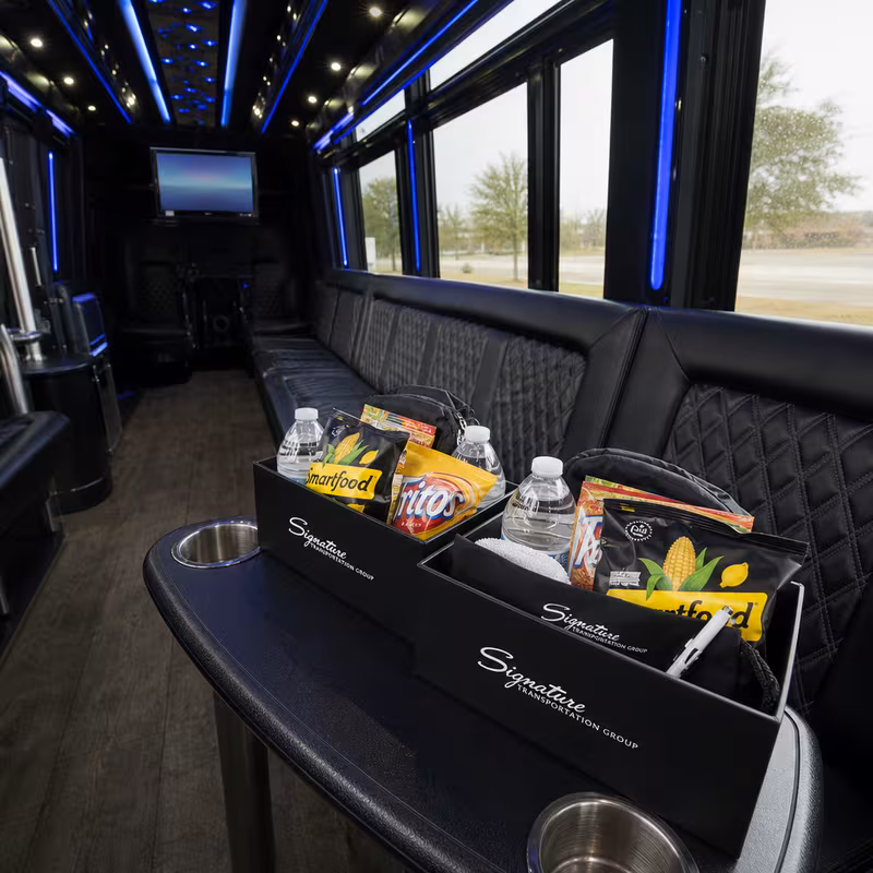 Party bus interior with wraparound leather seating and LED lighting in Kansas City